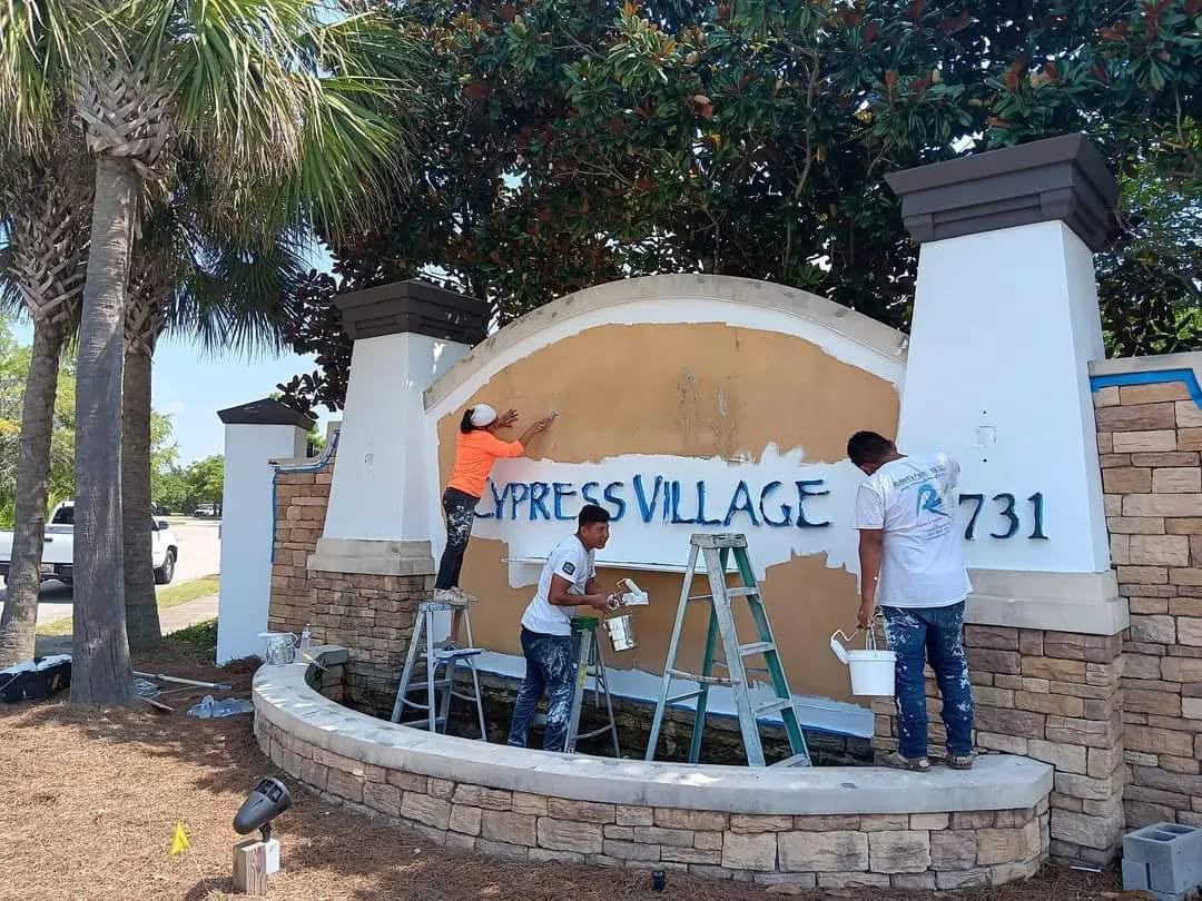 Crew painting Cypress Village community entrance sign