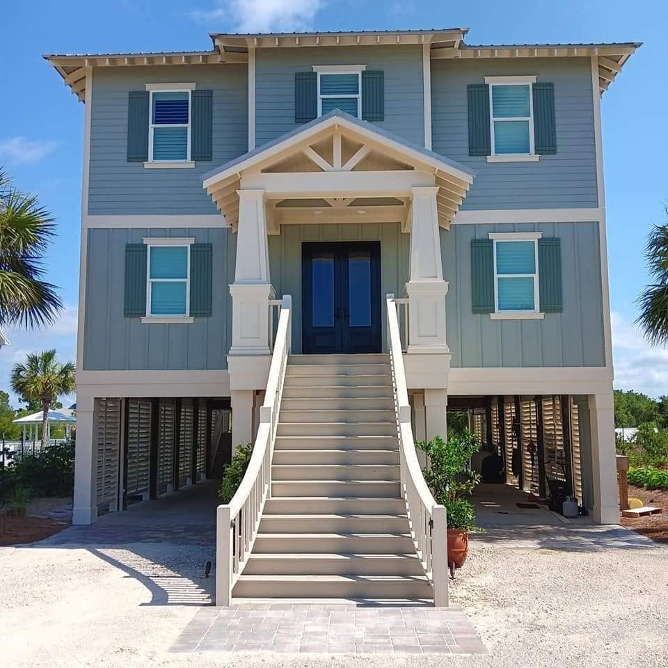 Blue stilted beach house with grand staircase